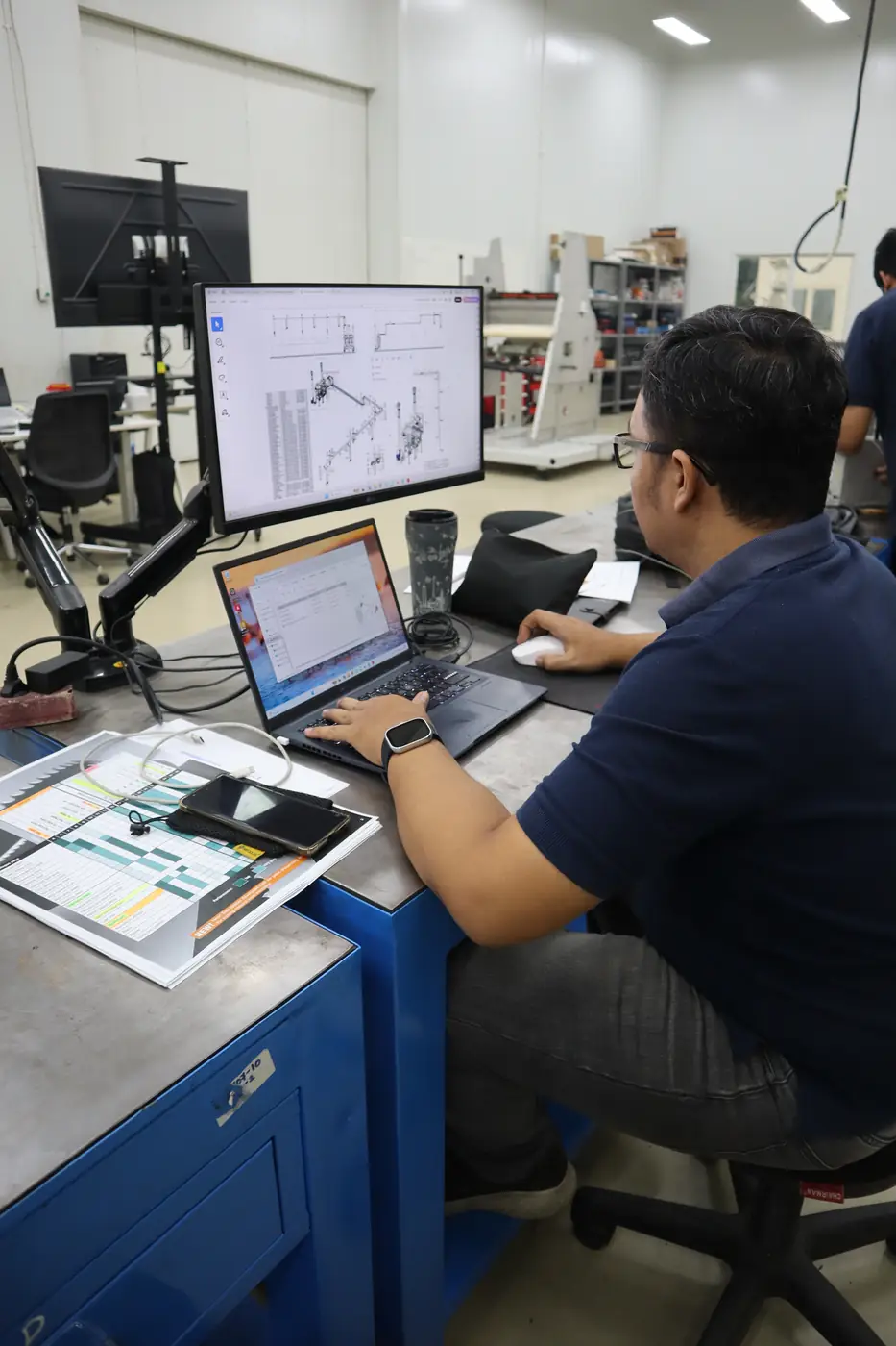 BMT engineer reviewing CAD technical drawings for tobacco processing machinery design in Surabaya